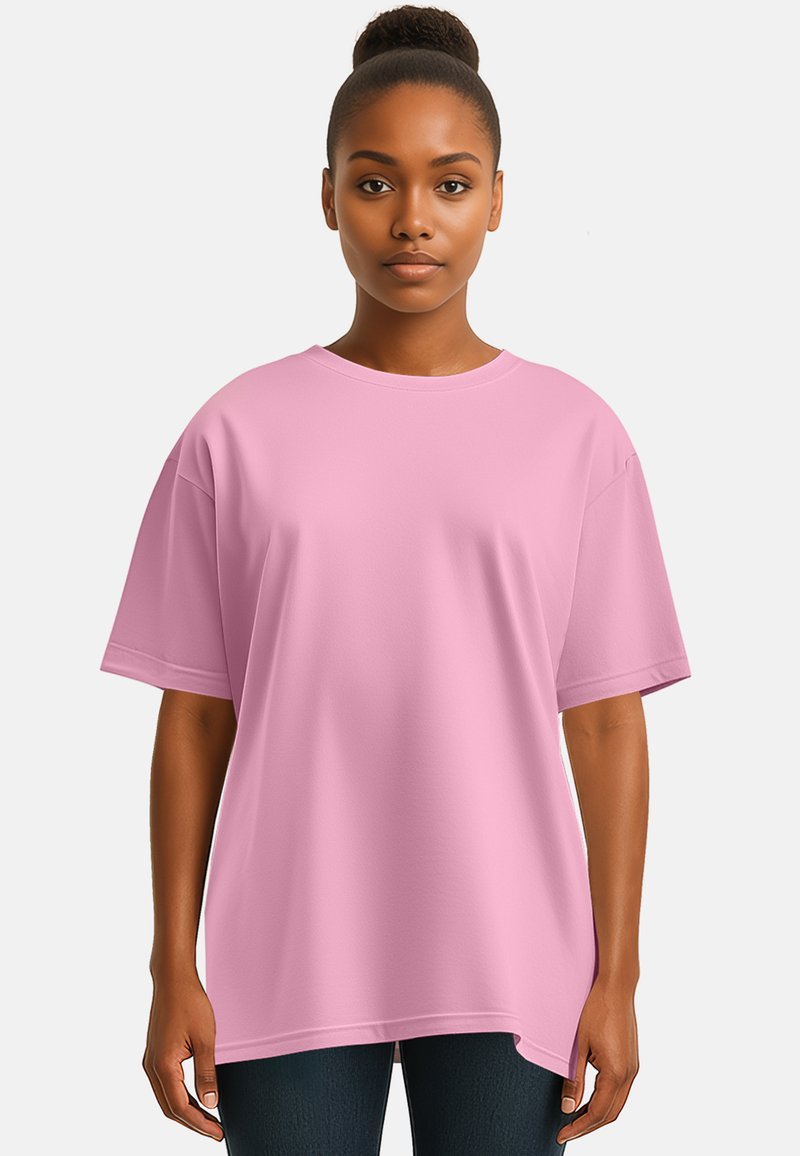 T-shirt in cotone di grandi dimensioni di colore rosa, con maniche corte, scollo rotondo e texture liscia; indossato da un modello su uno sfondo neutro.
