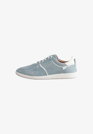 Lysblå ruskindsneakers med hvide detaljer, rund tå, flade snørebånd og tekstureret hvid gummisål. Har stikninger på siderne.