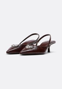 Braune Slingback-Schuhe aus Leder mit spitz zulaufender Vorderkante, kleinem Absatz und metallischem dekorativem Detail vorne. Glatte Textur und elegantes Design.