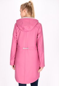 Giacca impermeabile rosa con cappuccio, cintura con cordino in vita, maniche lunghe e texture liscia, dotata di orlo arrotondato e dettagli in metallo argentato.