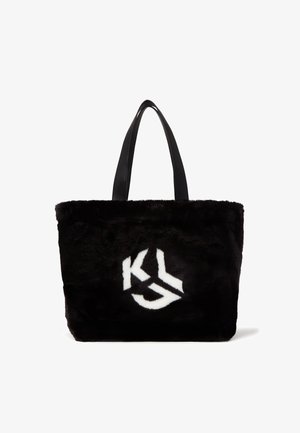 Sac cabas en fausse fourrure noire avec deux poignées en cuir noir et un logo "KL" blanc sur le devant. Texture douce avec un design robuste.