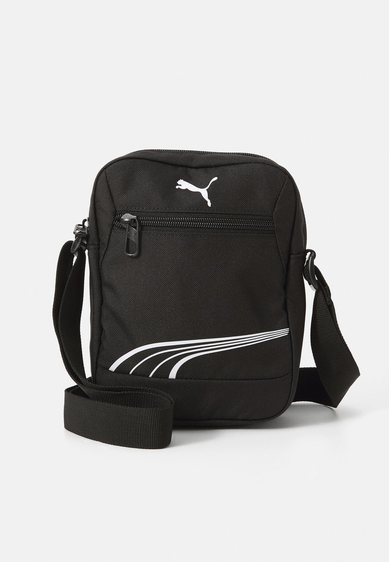 Bolso cruzado de tela negra con bolsillo frontal con cremallera, logo de Puma en blanco y diseño de franja curva blanca. Incluye correa ajustable.