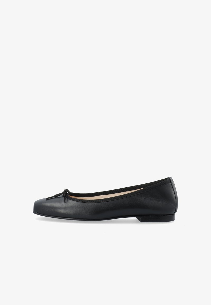Ballerines en cuir noir avec un bout arrondi et un profil slim. Présentent un petit nœud décoratif à l'avant et une semelle en caoutchouc plate.