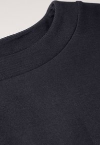 Sudadera gris oscuro con un cuello redondo acanalado. La tela parece suave y lisa, con una textura sutil y sin patrones ni acentos visibles.