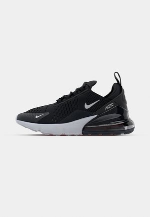 Zapatilla deportiva negra con parte superior de malla, mediopie blanca y amortiguación de aire visible en el talón. Diseño elegante con sutiles acentos plateados.