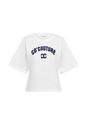 Λευκό T-shirt με κοντά μανίκια, φαρδιά μανίκια και ναυτικό μπλε κείμενο και λογότυπο "CO'COUTURE" στο μπροστινό μέρος.
