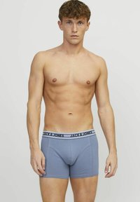 Blauwe katoenen boxershorts met een zwart-witte tailleband met het "JACK & JONES" logo. Glad textuur, aansluitend ontwerp en lengte tot halverwege de dij.
