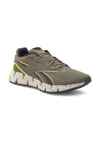 Vīriešu skriešanas apavi ar zaļu tīkla virsmu un melniem akcentiem. Bieza, raibā baltā vidussole, ar strukturētu saķeres zoli.