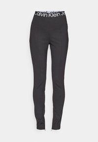Schwarze Stretchleggings mit einem elastischen Bund, der das Calvin Klein-Logo trägt. Sie haben eine schmale Passform und Reißverschlüsse an den Knöcheln für verstellbare Beinöffnungen.
