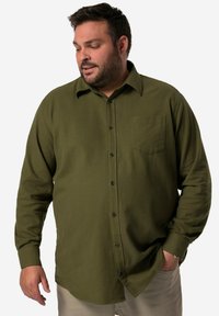 Camicia verde oliva con bottoni in morbido tessuto, dotata di tasca sul petto sinistro, bottoni neri e un design del colletto classico.