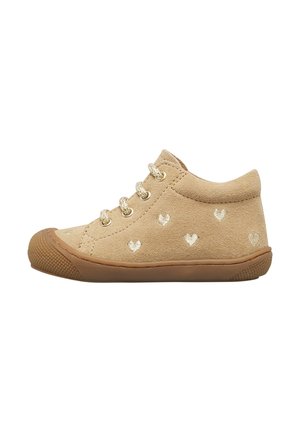 Scarpa da bambino in camoscio beige con suola in gomma marrone chiaro, chiusura con lacci e piccoli motivi a cuore bianchi sui lati.