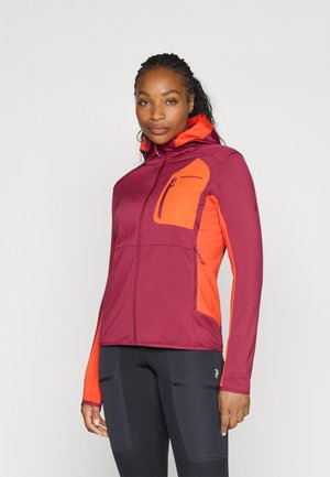 Dames prestatie jack met een kastanjebruine body en oranje accenten, met ritszakken, een getailleerd ontwerp en een capuchon.