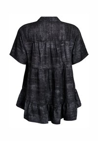 Loose-fitting black short-sleeve blouse with tiered, gathered fabric layers and a subtle textured pattern, shown from the back.
