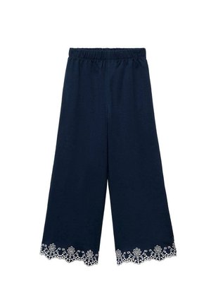 Tmavě modré široké kalhoty s elastickým pasem a bílou květinovou krajkou podél lemu, vyrobené z měkkého bavlněného materiálu.