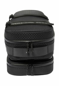 Schwarze Tasche mit zwei Fächern und strukturiertem Rautenmuster, aus recycelten Materialien, mit Reißverschlüssen und flachen Griffen. Kompaktes und funktionales Design.