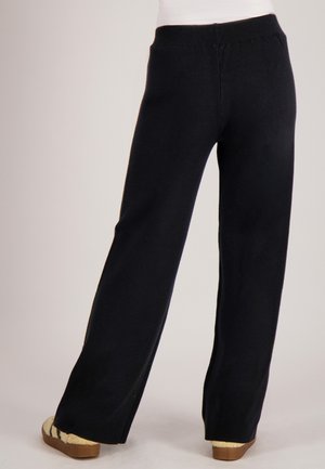 Zwarte broek met wijde pijpen en een rekbare tailleband, met een gladde textuur en een rechte snit, gezien van de achterkant.