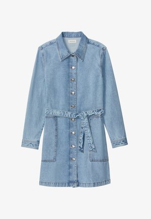 Φόρεμα από ανοιχτό μπλε τζιν με μακριά μανίκια, γιακά, κουμπιά μπροστά, δύο μεγάλες τσέπες και ζώνη στη μέση που δένει.