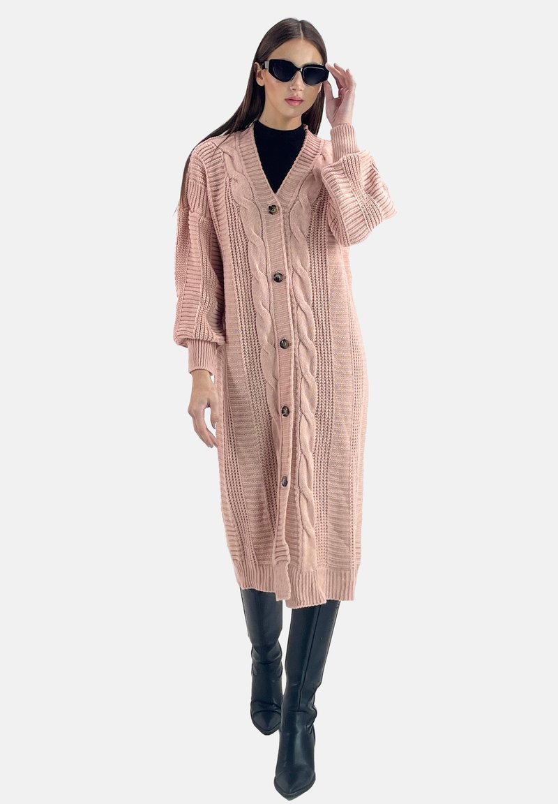 Rosa gestrickte Strickjacke mit Kabelmustern, langen Ärmeln und Knöpfen vorne, kombiniert mit schwarzen hohen Stiefeln.