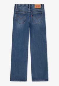 Plave traperice ravnog kroja, s dva stražnja džepa s karakterističnim šavom i kožnom etiketa s brendom na struku.