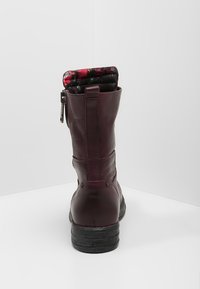 Stivale al ginocchio color borgogna scuro con zip, fodera interna ripiegata che mostra un motivo floreale, posizionato su uno sfondo bianco.
