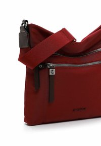Borsa a spalla in nylon rosso con design morbido, dotata di cerniere in argento, dettagli in pelle scura e una tracolla staccabile per una maggiore versatilità.