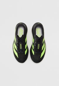 Schwarze sportliche Sneakers mit leuchtend grünen Akzenten. Verfügt über ein strukturiertes Obermaterial, eine Schnürung und ein "ADIZERO"-Logo auf der Zunge.
