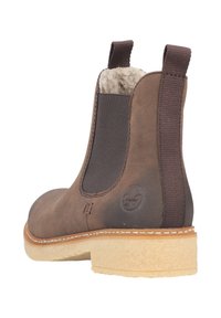 Bottines en cuir marron avec des panneaux élastiques sur les côtés, semelle en caoutchouc texturé tan et doublure douce. Coutures renforcées près de la semelle.