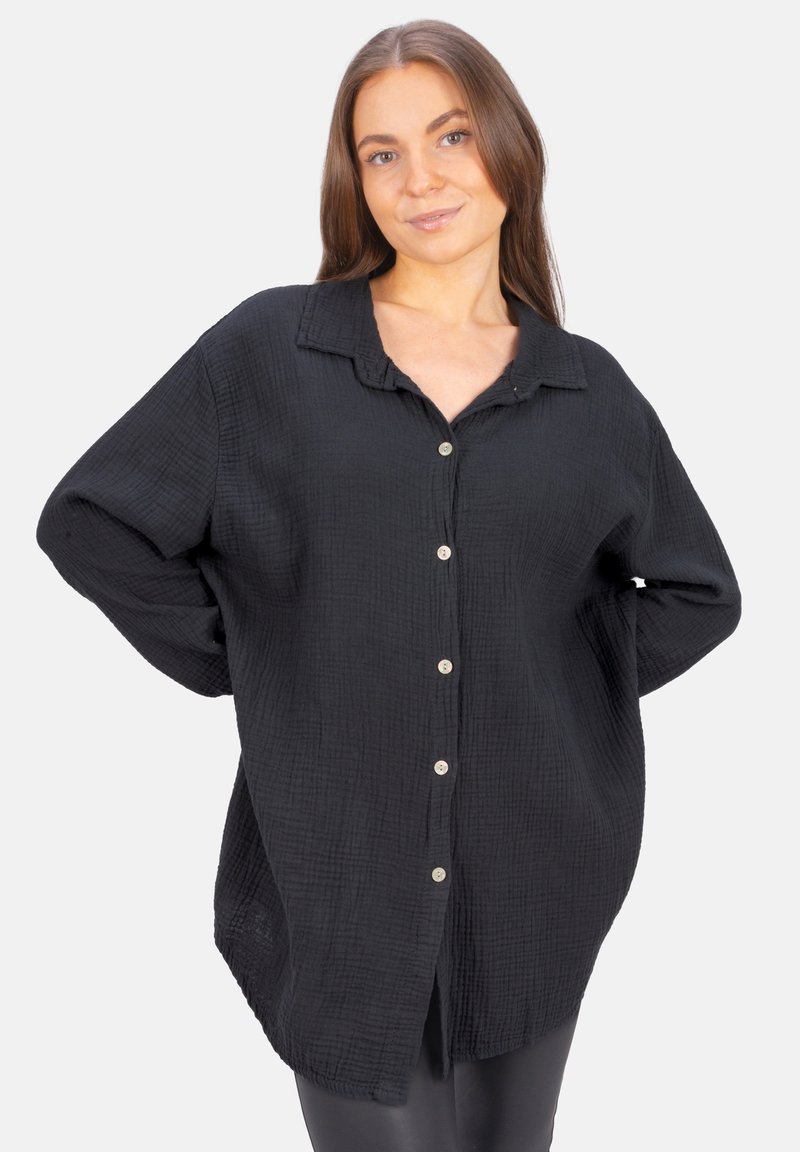 Black button-up shirt in textured fabric, featuring a collar, long sleeves, and a slightly oversized fit with side slits.