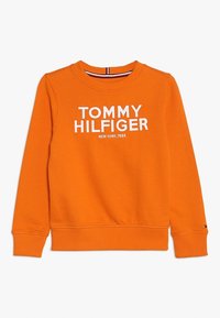 Oranžová mikina s dlouhým rukávem a kulatým výstřihem s bílým potiskem "Tommy Hilfiger New York, 1985" na přední straně, žebrované manžety a lem.