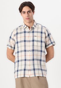 Camisa de manga curta xadrez em bege claro, azul e laranja. Apresenta um bolso no peito, gola com botão e um corte confortável.