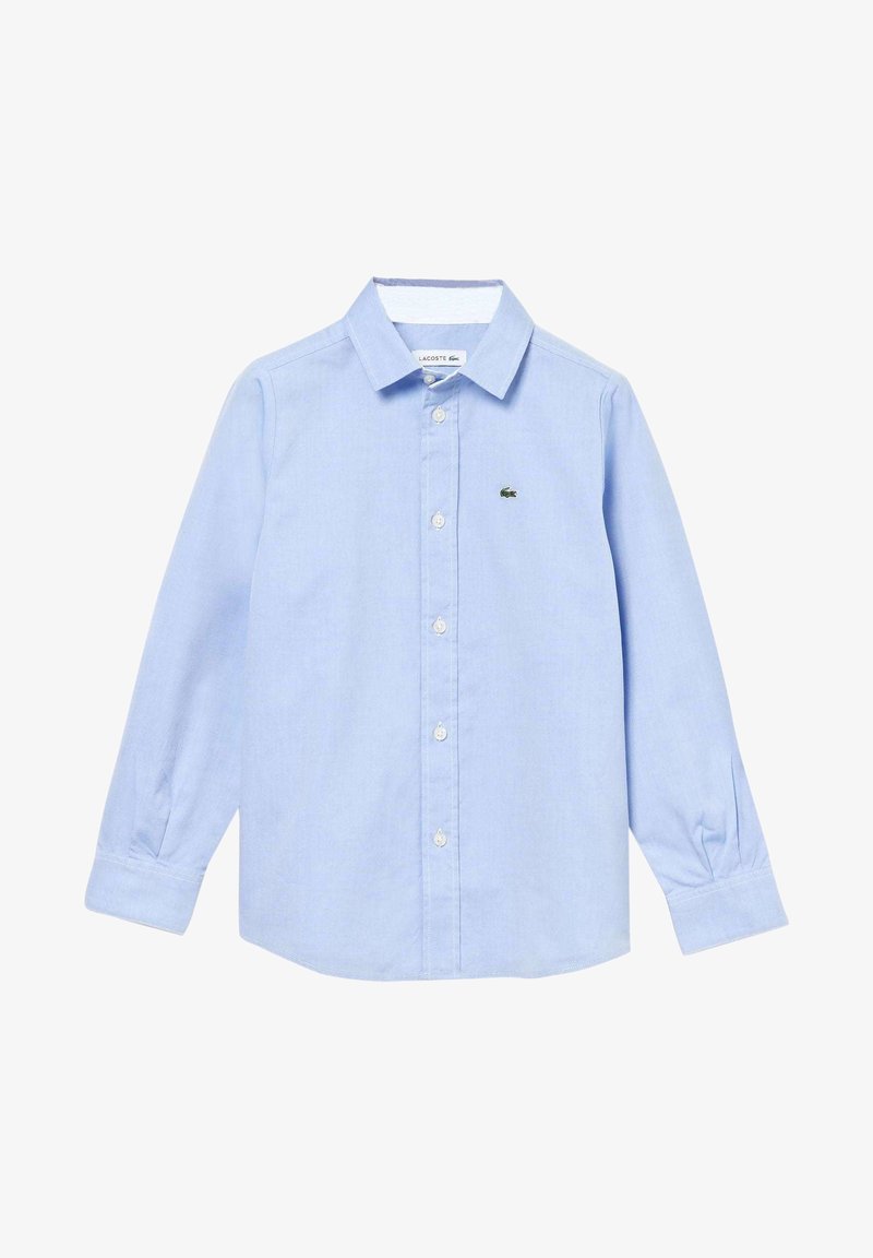 Chemise bleu clair à manches longues avec col et petit logo de crocodile vert sur la poitrine gauche.