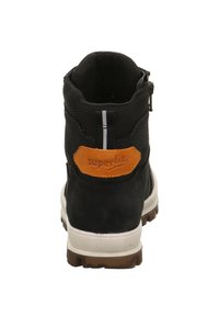 Czarny zamszowy botek za kostkę z szarą górą z materiału tekstylnego, pomarańczową naszywką z logo, białą i brązową podeszwą oraz tylnym zamkiem błyskawicznym. Posiada tylny odblaskowy pasek.