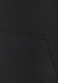 Čierna tkanina s hladkým povrchom, ktorá má všitú kapsu. Jemný rebrovaný vzor pridáva hĺbku na povrchu.