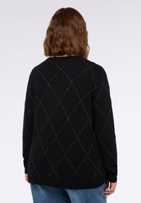 Zwarte gebreide trui met een ruitpatroon en metallic draden. Ontspannen pasvorm, geribbelde kraag en zoom, lange mouwen, casual ontwerp.