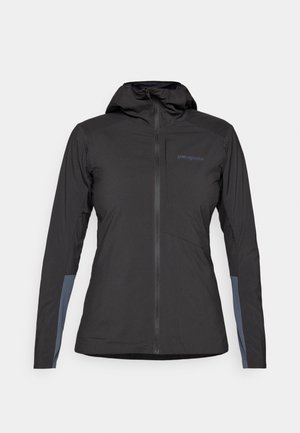 Giacca con cappuccio Patagonia nera con zip frontale e patch grigi sulle maniche interne, esposta su uno sfondo bianco.