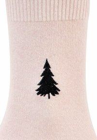 Hellrosa Socke mit geripptem Bündchen und schwarzer Baum-Silhouette in der Mitte. Hergestellt aus weichem, strukturiertem Stoff.
