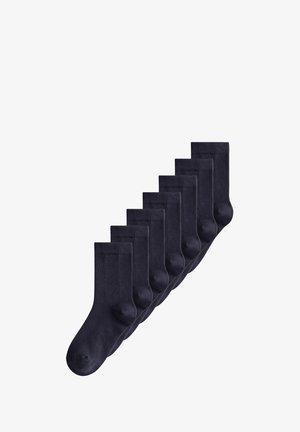 Sieben Paare schlichte schwarze knöchelhohe Socken, diagonal auf weißem Hintergrund angeordnet.