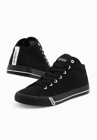 Černé vysoké plátěné tenisky s bílými očky, šněrováním a proužky na podrážkách, značkované "ombre" na jazyku, zadním štítku a bočním štítku.