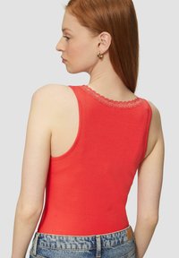 Rode geribbelde tanktop met een kantafwerking bij de hals, gedragen met hoge taille denim shorts, die een aansluitend ontwerp en gladde textuur benadrukken.