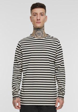 Langermet genser med rund hals i svart og hvite horisontale striper, laget av mykt stoff med en avslappet passform og enkle sømdetaljer.