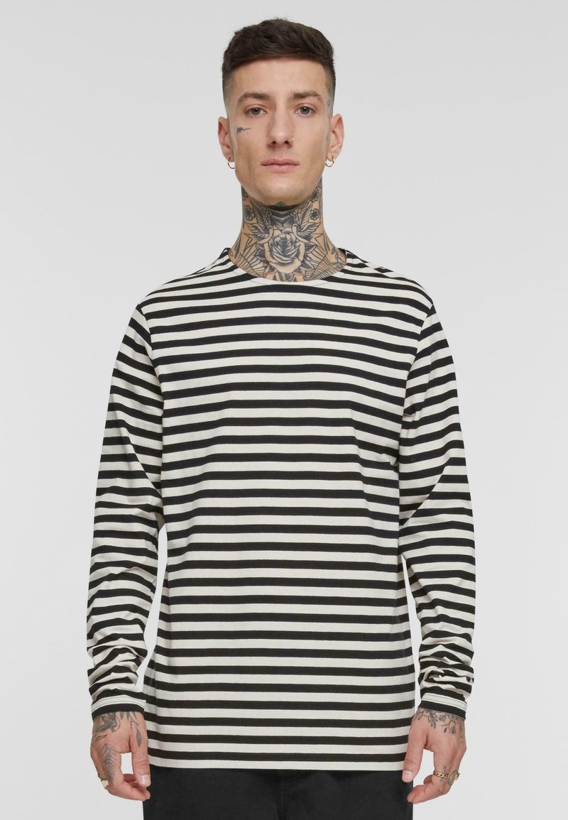 Langärmliges Rundhals-Shirt mit schwarz-weißen horizontalen Streifen, aus weichem Stoff mit lockerer Passform und einfachen Steppnähten.