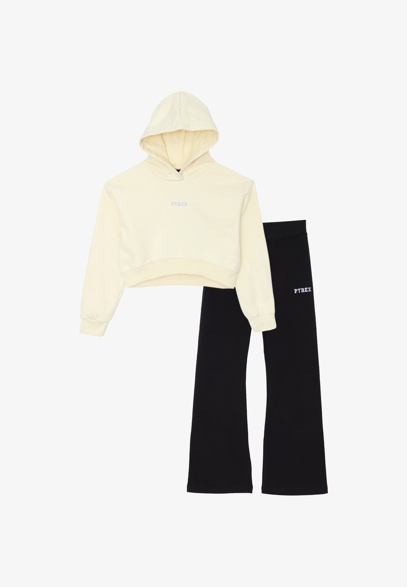 Felpa corta crema con cappuccio, dotata di cordino e logo, abbinata a pantaloni della tuta neri a palazzo con lo stesso logo. Materiale in misto cotone.