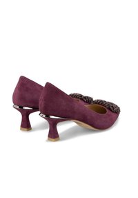 Purple suede heels with a low, flared heel and beaded embellishment on the toe. Smooth texture with a slight shine on the hardware.