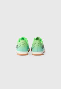 Groene gradient sneakers met een gladde textuur, zwarte logo-detail en beige rubberen zool. De achterkant toont het afgeronde hakontwerp.