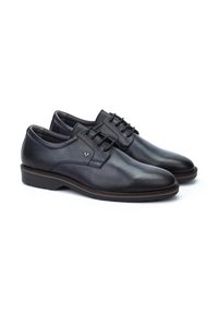 Chaussures habillées en cuir noir avec une finition lisse, bout rond, design à lacets et détails de couture subtils. Semelle en caoutchouc de profil bas.