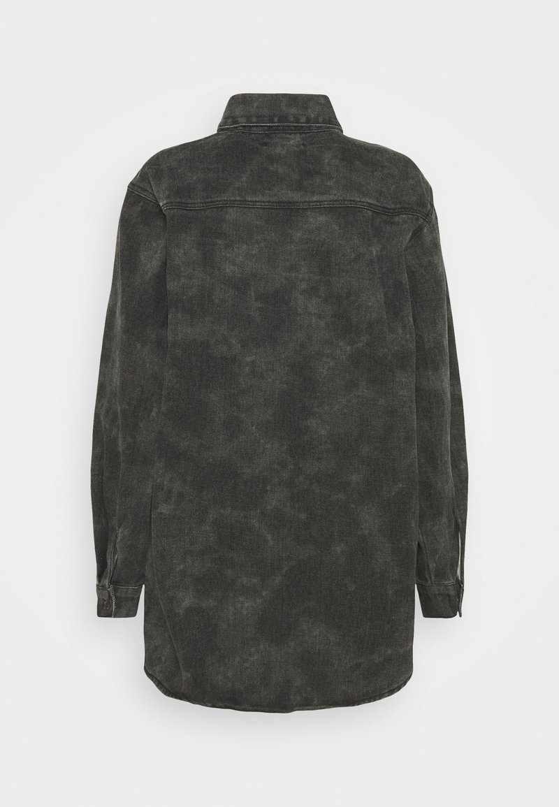 Svart denimskjorta med krage, långa ärmar och en något urtvättad textur, rak skärning och sidoventiler vid fållen.