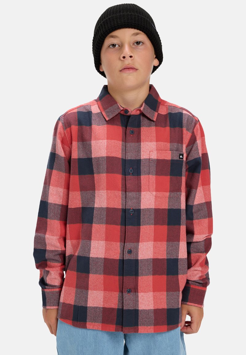 Rood en marine blauw geblokt flanellen shirt met een knopenborst, kraag en zak op de linkerborst. Gekocht met een zwarte gebreide beanie.