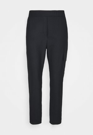 Zwarte broek van zacht materiaal, met een slim fit, zijzakken en een strakke uitstraling. Geen zichtbare sluitingen of versieringen.