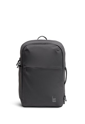 Sac à dos rectangulaire gris foncé avec poche avant zippée, poignée latérale, boucle supérieure et logo "GOT BAG." en bas à droite.