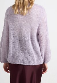 Maglione lavorato a maglia lavanda con una vestibilità ampia, caratterizzato da un design testurizzato e arioso e un orlo arricciato, abbinato a una gonna bordeaux scuro.